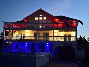 Ein zweistöckiges Haus mit Balkon, Garage und überdachter Veranda.