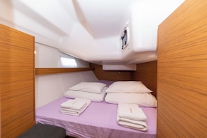 A compact cabin with a single bed, wooden paneling, a small window, and a ceiling-mounted light fixture. - Sun-Kissed Sailing Adventure in Zadar, Croatia (Zadar)