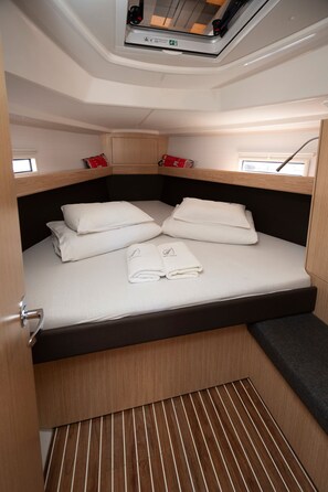 A compact bed with a headboard, a window with a view, and a small storage area above the bed. - Sun-Kissed Sailing Adventure in Zadar, Croatia (Zadar)