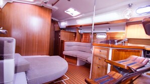 A compact interior with a bunk bed, a small kitchenette, and a seating area.