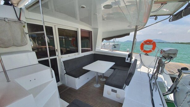 Ein Bootsdeck mit Sitzgelegenheiten, einem Tisch und einem Rettungsflossenhalter.