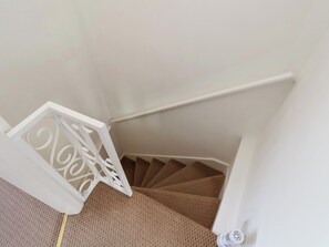 A staircase with a white handrail and a white door with a decorative design. - 4 Studley Terrace (Whitby)