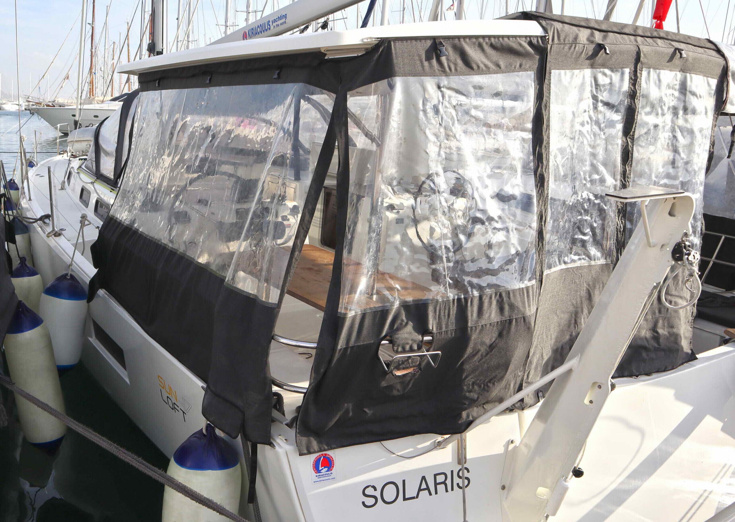 Um barco chamado 'SOLARIS' com cabine coberta, leme e uma sacola 'SUN LOFT'.