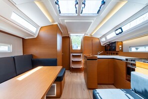 Interior d'una caravana compacta amb zona de menjador, petita cuina i seients.