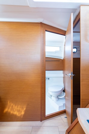 Ein Badezimmer aus Holz mit Toilette, Dusche und Waschbecken.