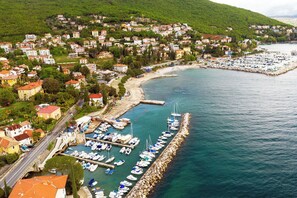 A coastal town with a marina, residential buildings, and a road leading to the waterfront.