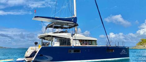 A large yacht with a covered deck, a cabin, and a helipad.
