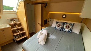 Una camera compatta con un letto, una scrivania, una sedia, un armadio e una finestra.