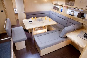 A compact living space with a sofa, a small table, and a laptop. - Sun-Kissed Sailing Adventure in Islas Baleares, Mallorca (Palma)