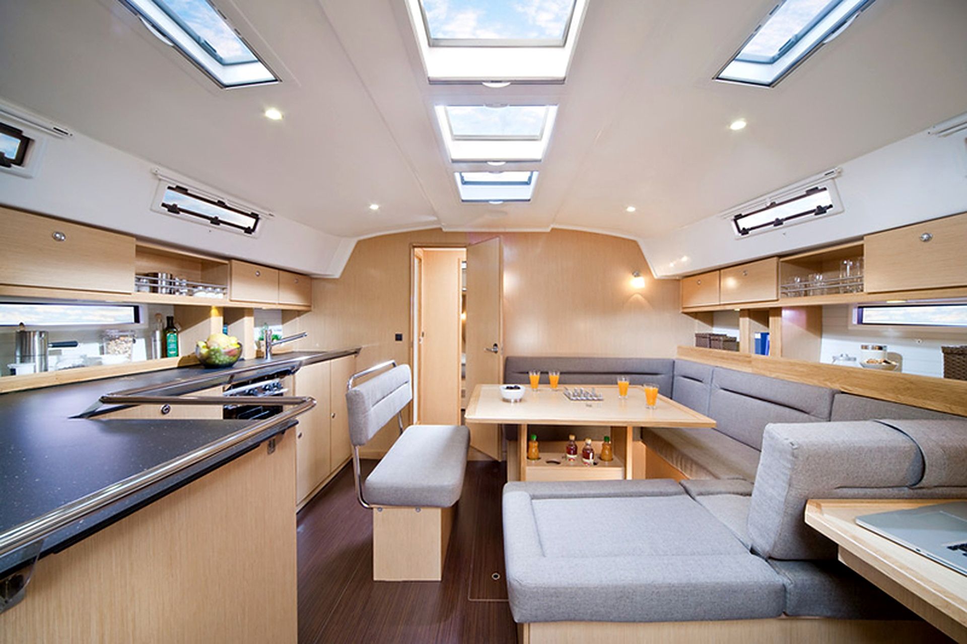 A compact kitchen with a central island, a dining area with a bench, and overhead skylights.