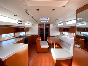 A compact kitchen with a central island, seating area, and a view through the door.