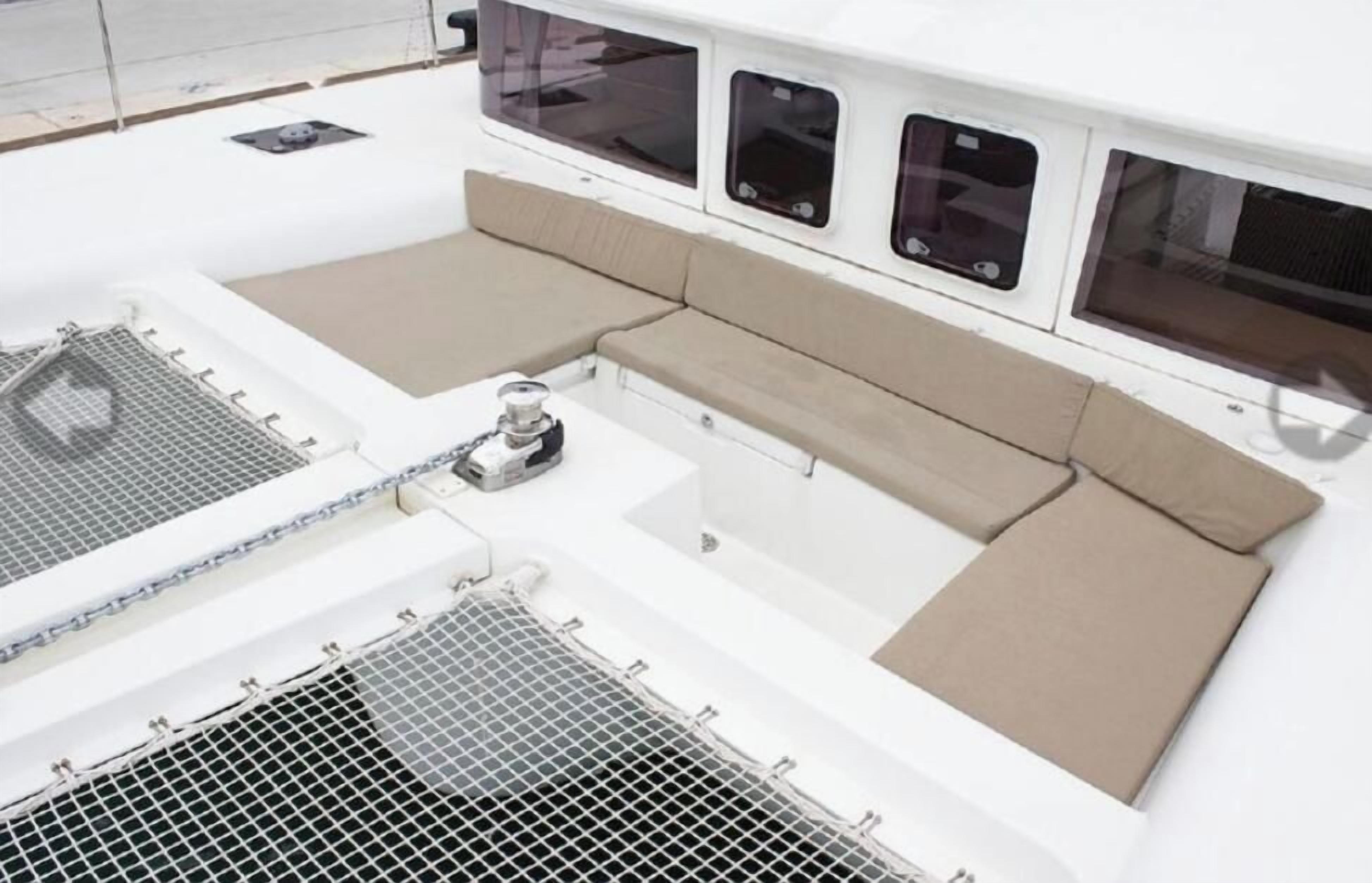 A boat deck with seating areas, windows, and a control panel.