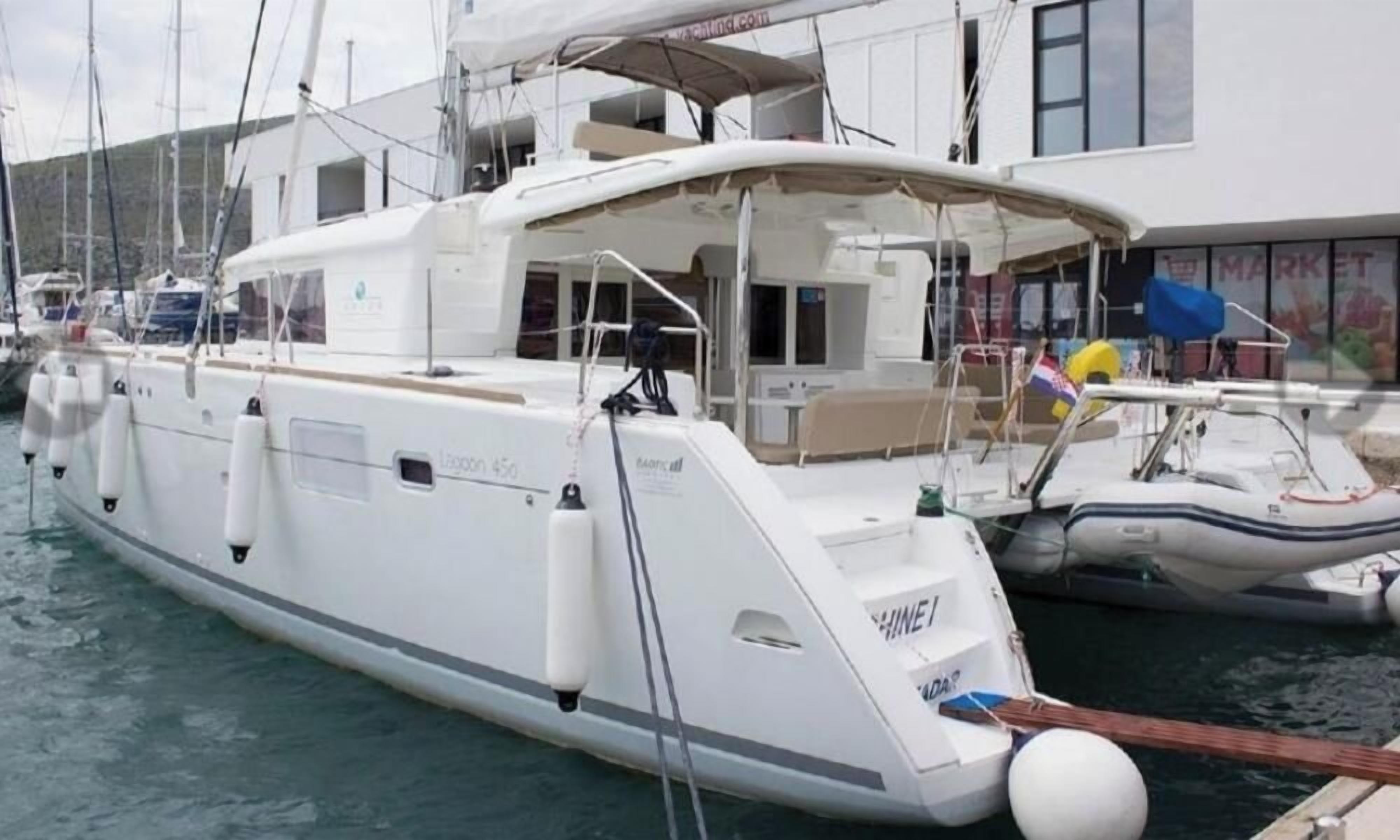 A marina with several boats docked, including a white yacht with a covered deck and a smaller motorboat.
