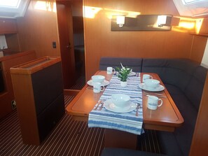 A dining area with a table set for two, a small plant, and a bench. - Sun-Kissed Sailing Adventure in Northern Croatia (Punat)