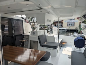 L’intérieur d’un bateau comprend un coin salon, une petite table et un barbecue.