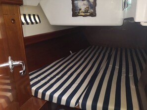 A compact cabin with a striped mattress, a small wooden cabinet, and a wall-mounted picture. - Sun-Kissed Sailing Adventure in the Ionian Islands, Lefkada (Lefkada)