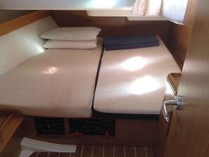 A compact cabin with a small bed, a window, and a door. - Sun-kissed Sailing Adventure in the Ionian Islands (Preveza)