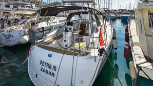 En lysthavn med flere sejlbåde i havnen, heriblandt en der hedder 'PETRA M ZADAR'.