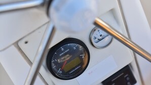 Et kontrolpanel med digital skærm, speedometer og måler, sandsynligvis en del af en bilens instrumentbræt.