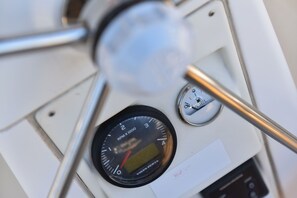 Ein Bedienfeld mit digitaler Anzeige, Tacho und Anzeigeinstrument, vermutlich Teil eines Fahrzeug-Armaturenbretts.
