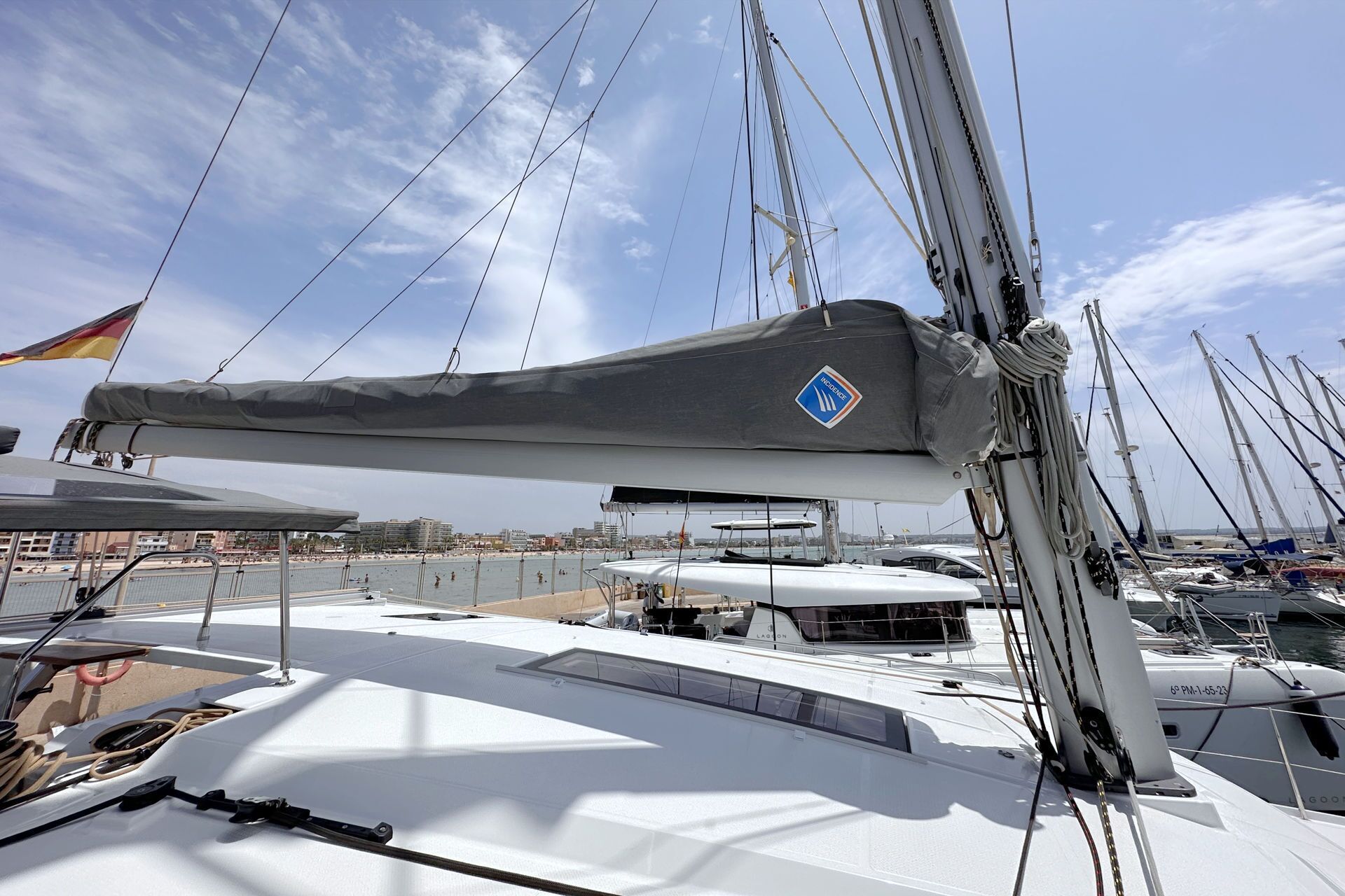 Un velero con vela gris, logo azul y casco blanco.