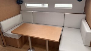 A compact, well-lit interior with a cushioned seating area, a small table, and a fan.