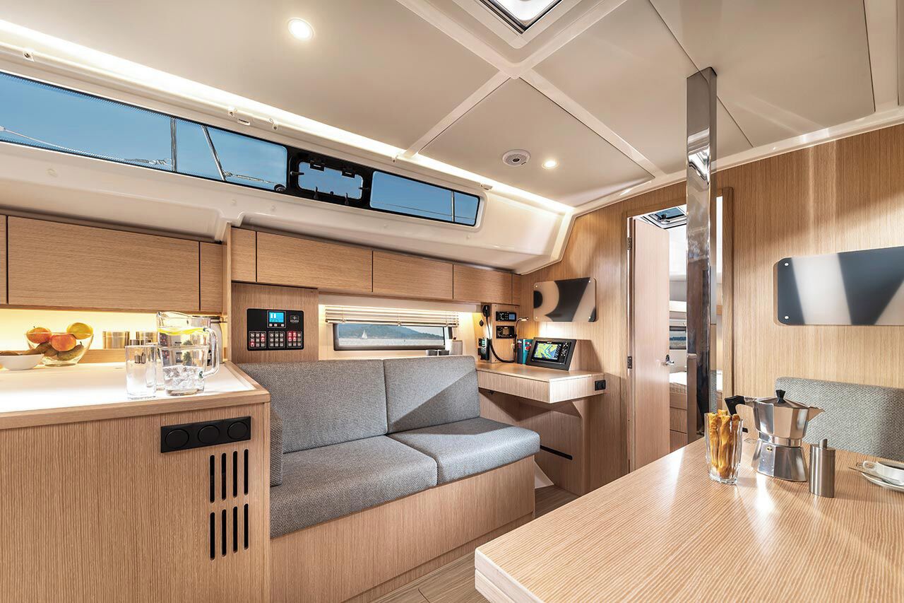 A compact kitchen with a built-in stove, a seating area with a cushioned bench, and a small dining table.
