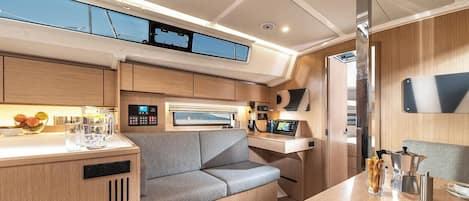 A compact kitchen with a built-in stove, a seating area with a cushioned bench, and a small dining table.