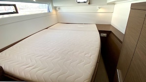 Ein kleines Zimmer mit einem Bett, einem kleinen Fenster und einem Holzschrank.