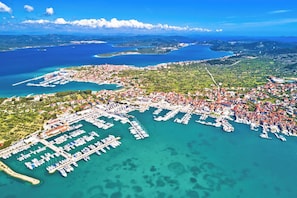An aerial view of a coastal town with a marina, boats, and surrounding greenery. - Sibenik Sun-Kissed Sailing: A Luxurious Beach Experience in Croatia (Murter)