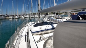 Ein Yachthafen mit mehreren Segelbooten, ein klarer, blauer Himmel und ruhige See.