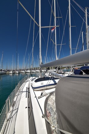 A marina with multiple sailboats docked, a clear blue sky, and a calm sea. - Sun-Kissed Sailing Adventure in Zadar, Croatia (Bibinje)
