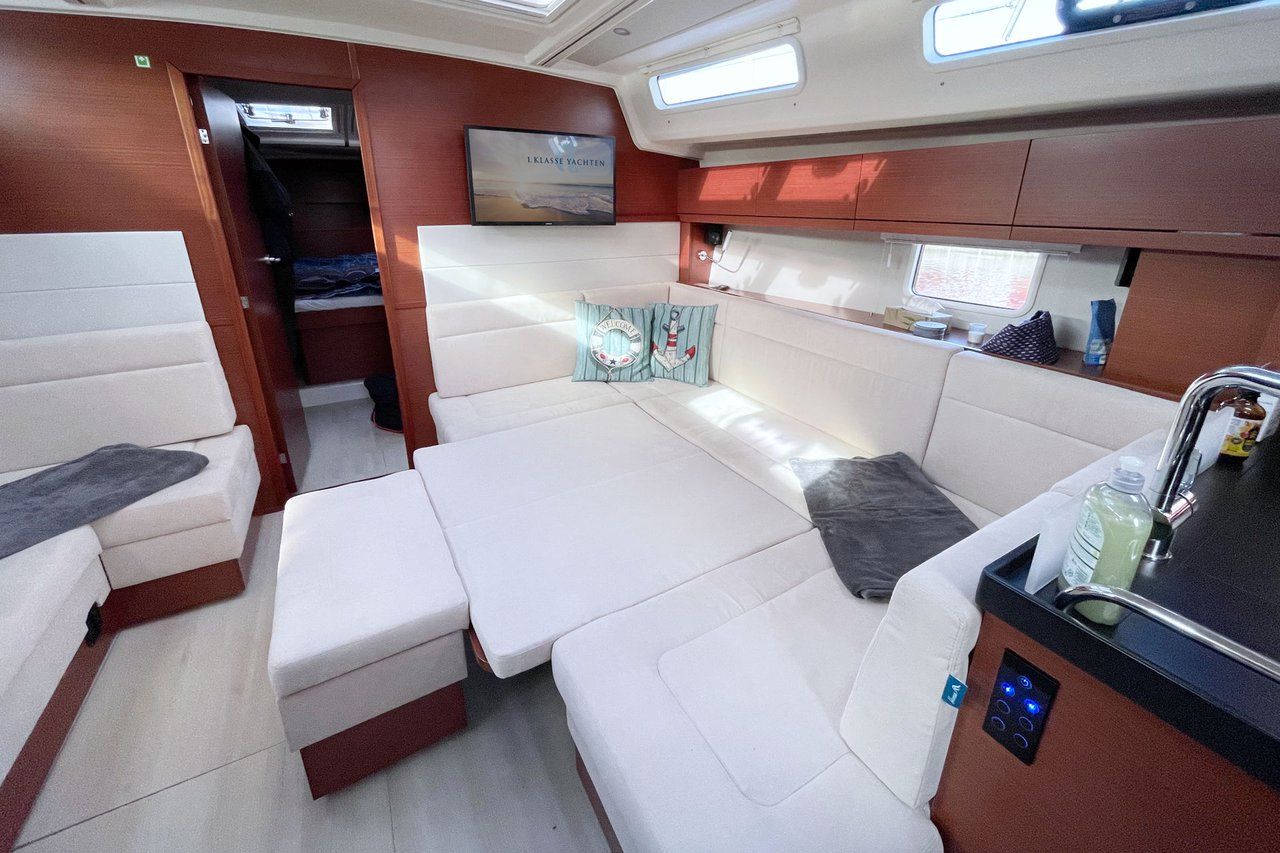 A compact interior with a seating area, a small kitchenette, and a television.