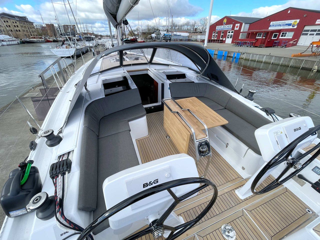 L'intérieur d'un bateau, avec un volant, un panneau de commande et un espace salon.