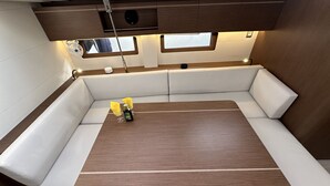 Ein kompakter, moderner Innenraum mit gepolsterten Sitzgelegenheiten, einem Holztisch und integrierter Beleuchtung.