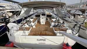 Ein Bootsdeck mit Steuerrad, Bedienfeld und dem Schriftzug 'FLIPPER HAMBURG' an der Seite.