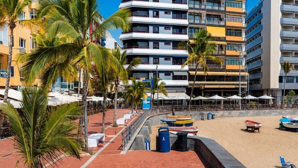 A beachfront hotel with a brick walkway, palm trees, and a sandy beach. - GuestReady - Las Canteras Shoreline (Las Palmas de Gran Canaria)