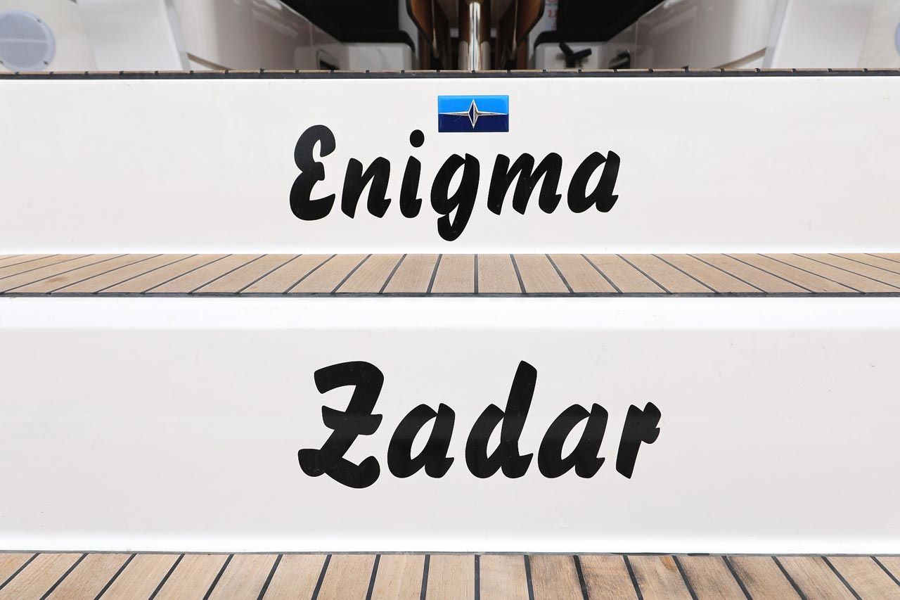 Un cartell amb les paraules 'Enigma' i 'Zadar' sobre un fons blanc.