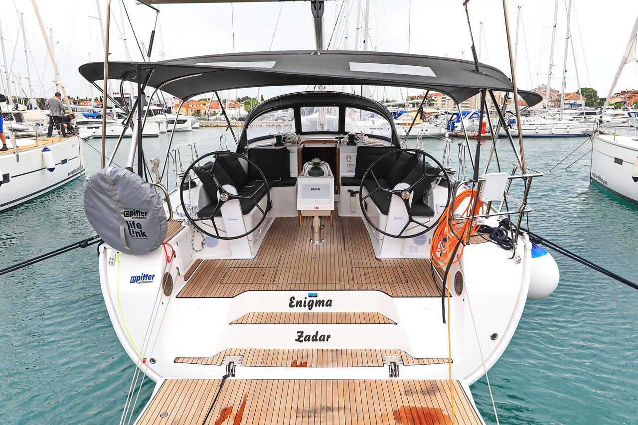 Ein Boot namens Enigma Zadar mit Holzboden, zwei Steuerrädern und einem überdachten Bereich.