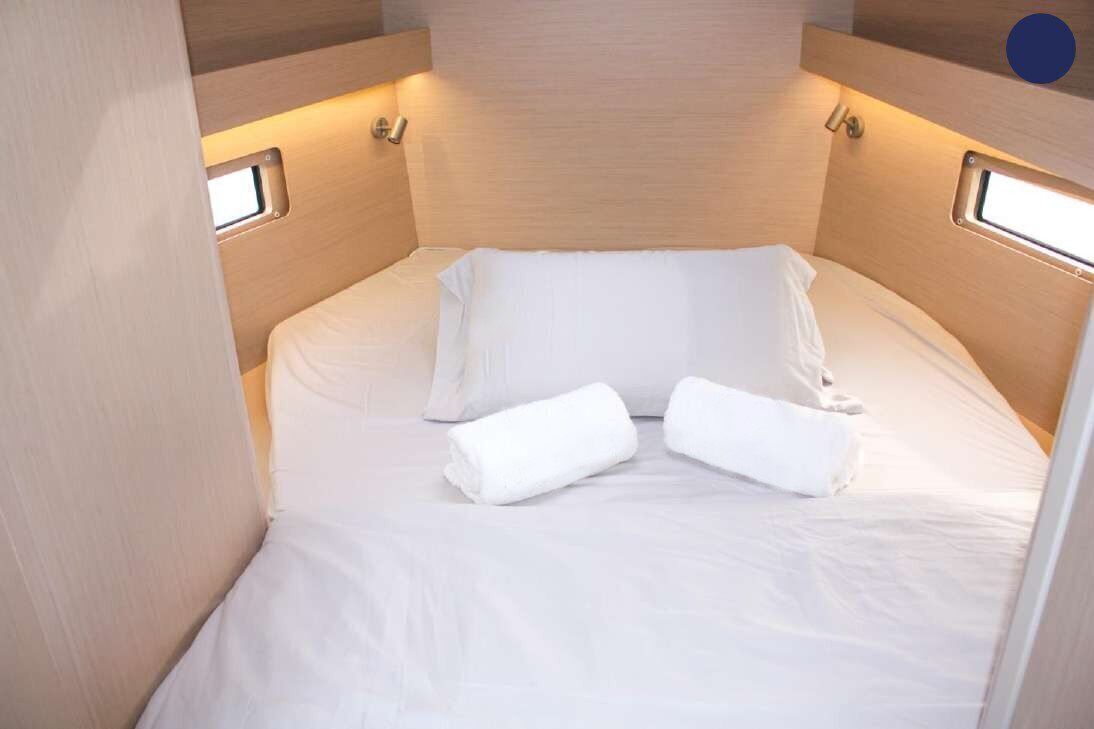 Una habitación pequeña y acogedora con una cama, dos mesitas de noche y un ventanal.