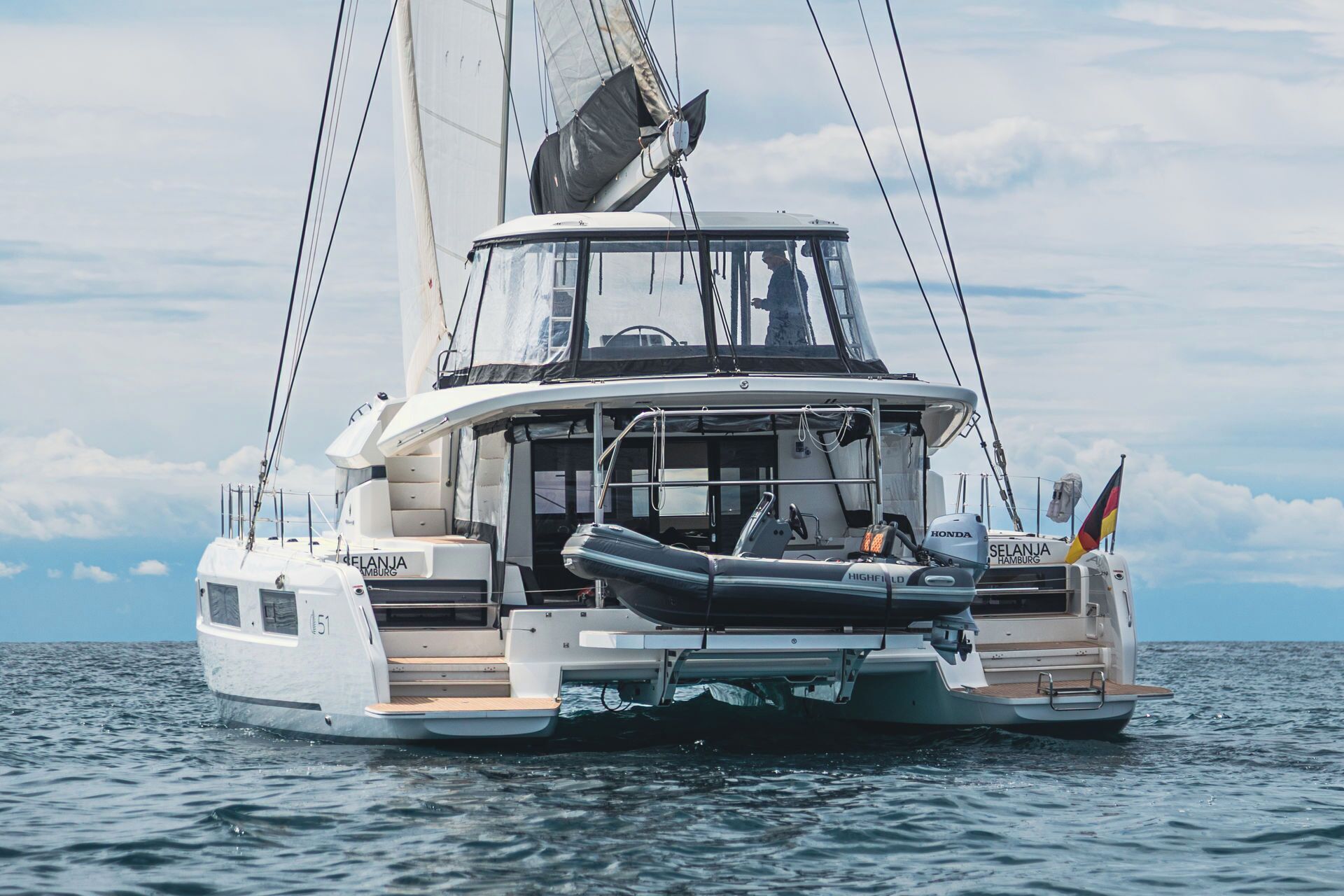 Un velero con camarote, timón y bandera.