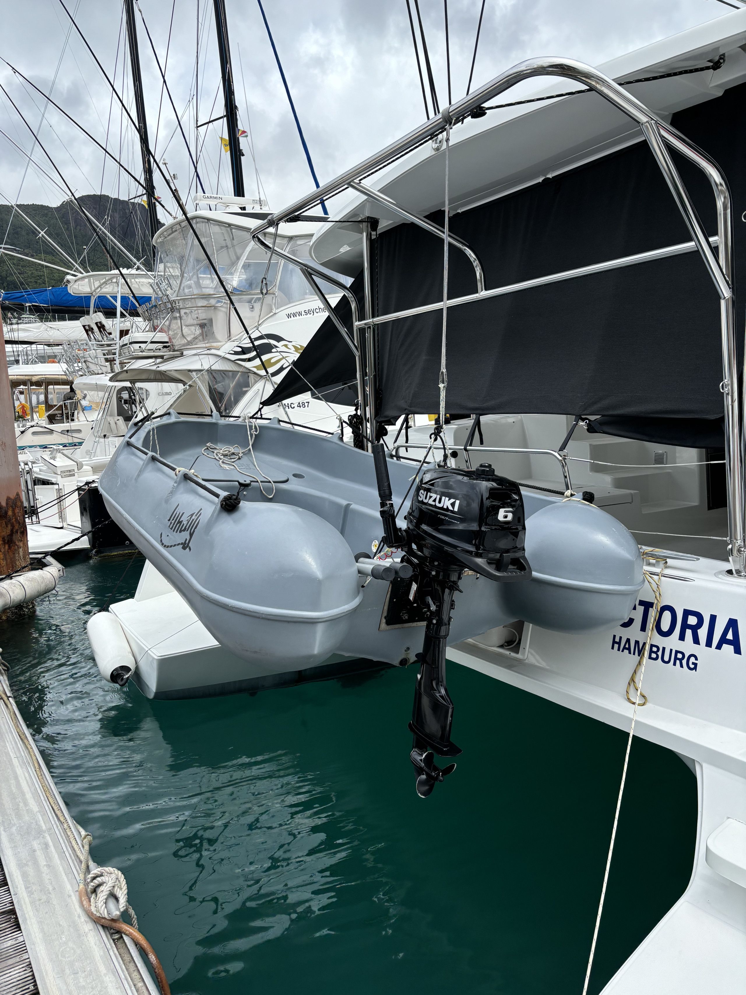 Un barco llamado 'TORIA' atracado en un puerto deportivo, con un motor fueraborda Suzuki visible.
