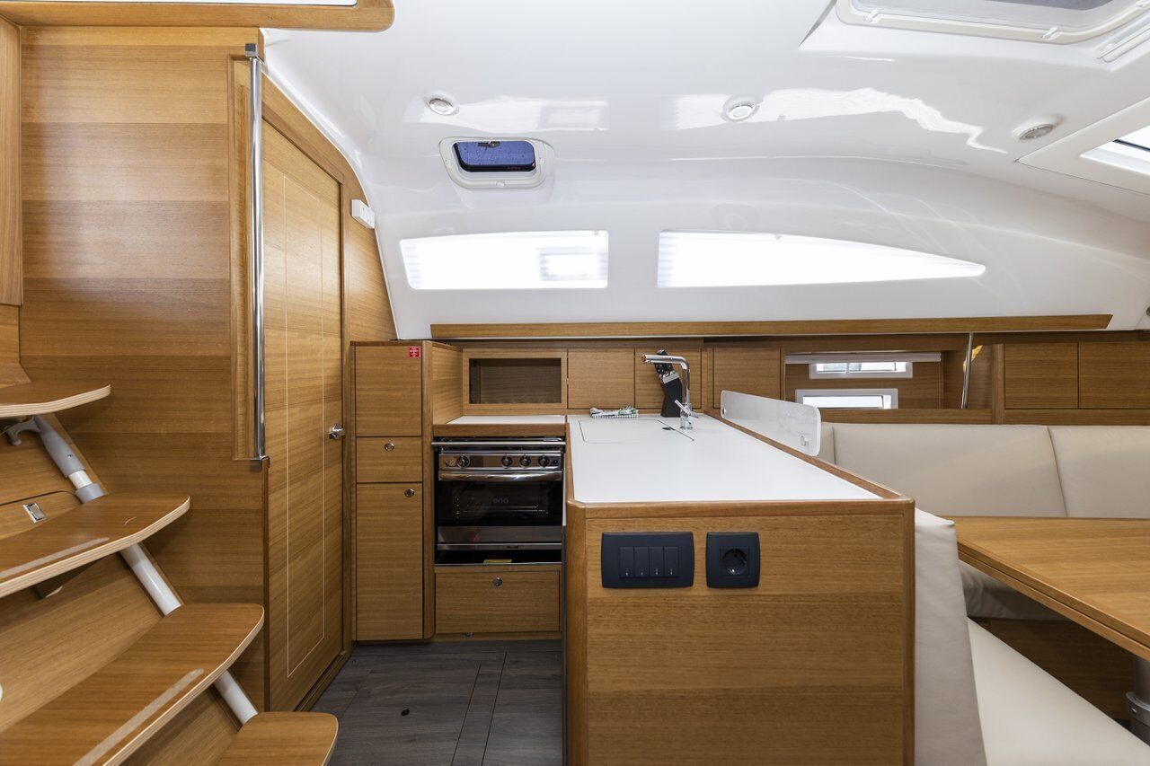 A compact galley with wooden cabinetry, a sink, and a stove.