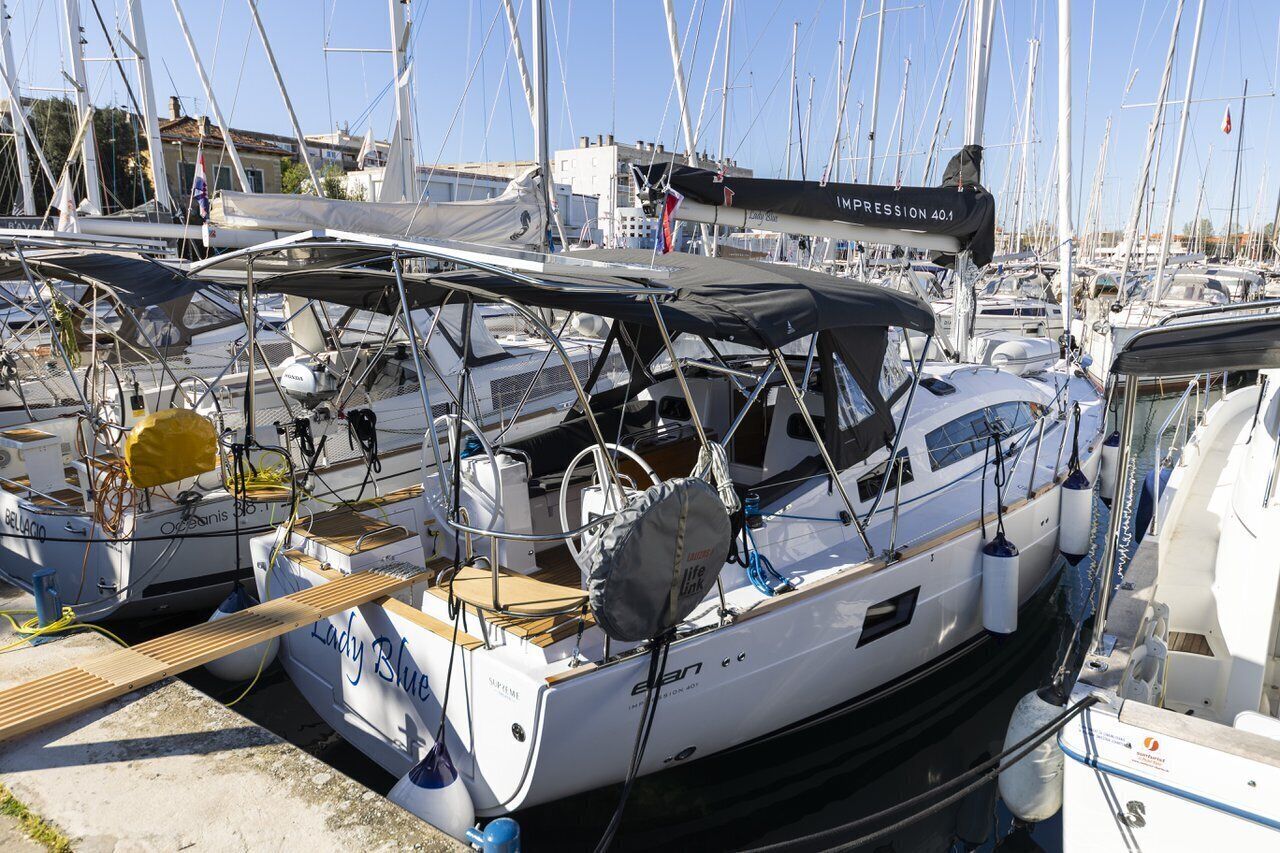 A marina with multiple sailboats docked, including one with 'Lady Blue' and 'IMPRESSION 40.1' visible on its side.
