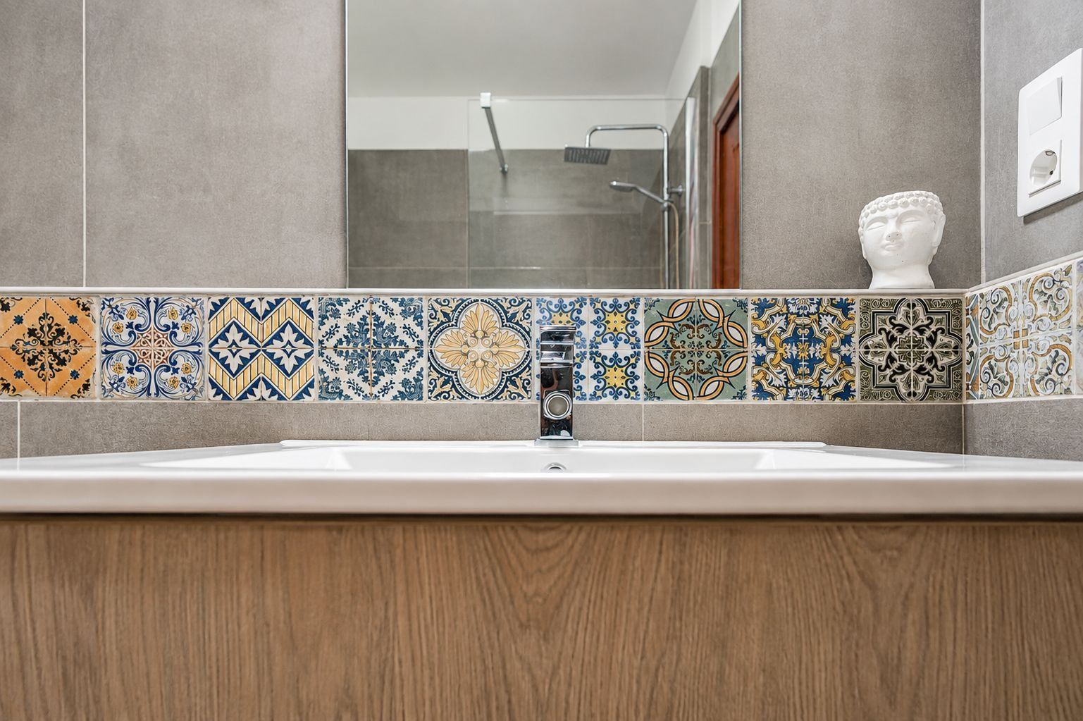 A bathroom with a wooden vanity, a sink, and a mirror.