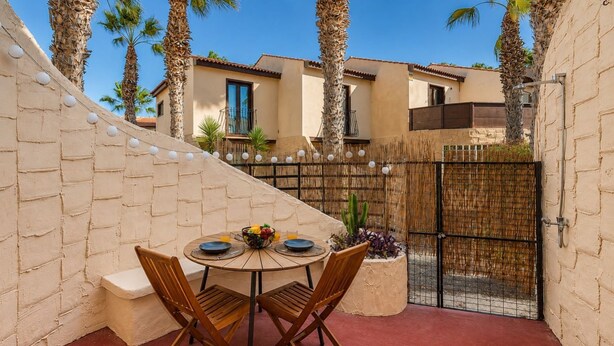 A patio with a round table, chairs, and a fruit bowl. - GuestReady - Duplex with Pool and Sunny Terrace (Parque Holandes)