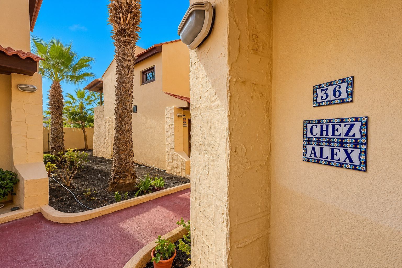 A residential area with numbered signs, a pathway, and palm trees.