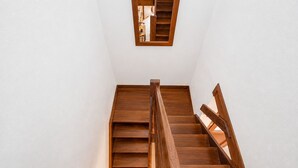 A wooden staircase with a handrail and a small window at the top. - GuestReady - Duplex with Pool and Sunny Terrace (Parque Holandes)