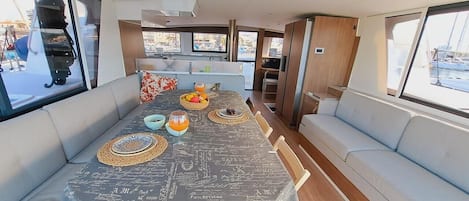A dining area with a table set for four, a sofa, and a view of the marina.