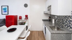 A compact kitchen with a microwave, coffee maker, and toaster on the counter. - GuestReady - Balcon de Amadores Sea View (Puerto Rico)